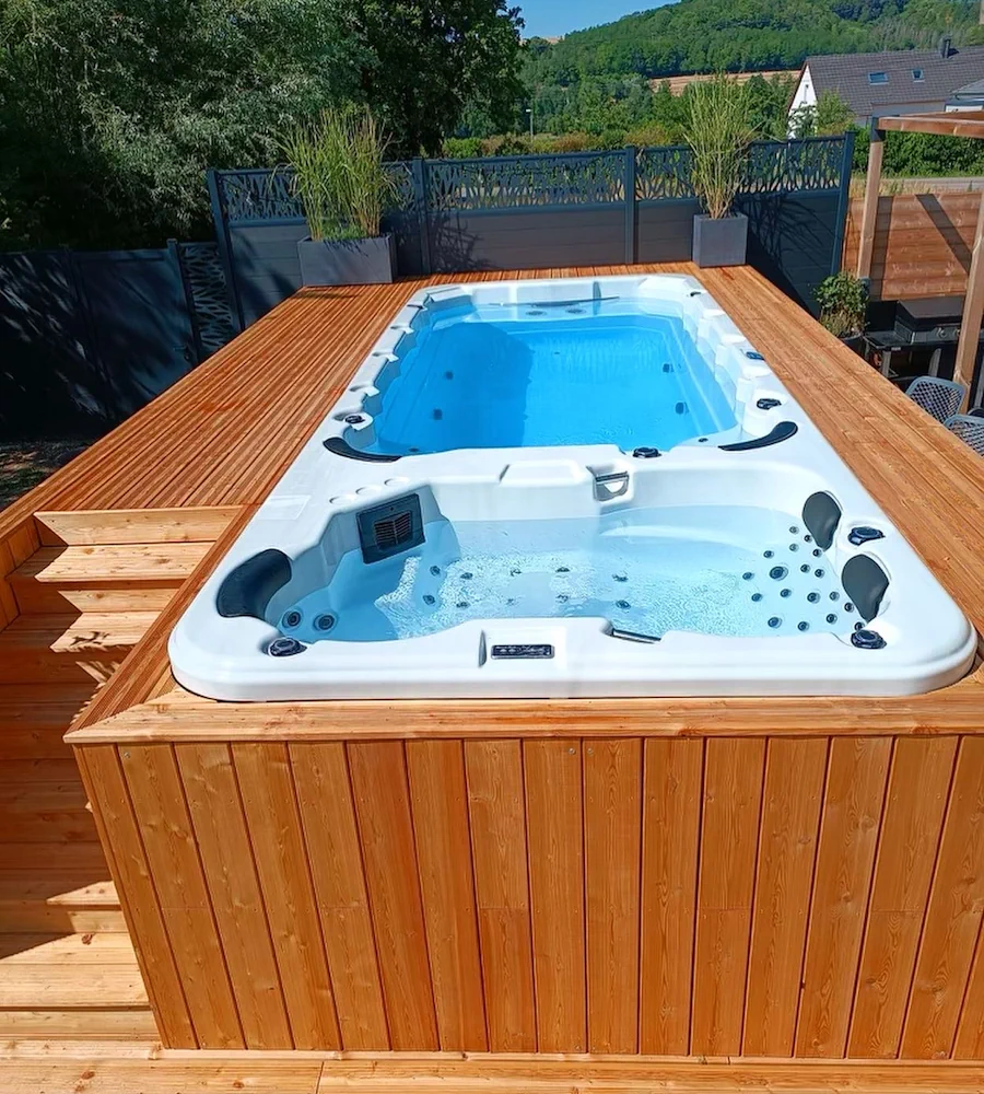 Spa de nage habillé de bois dans un jardin